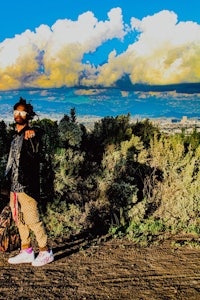 a person standing on a dirt road with a backpack
