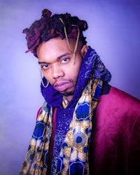 a man with dreadlocks and a colorful scarf